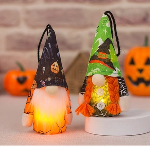 Close-up of glowing Halloween gnomes with LED lights, boo pumpkin hats and spider web motifs
