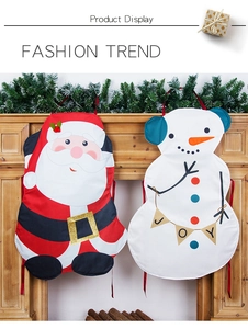 Detail of Santa and Snowman Christmas aprons with sequin belt and JOY banner hanging on a mantel