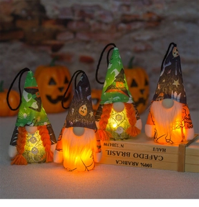 Detailed view of four glowing Halloween gnomes with warm LED lights and spider web patterns