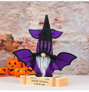 Detailed view of Halloween gnome plush with purple bat wings on rustic brick wall