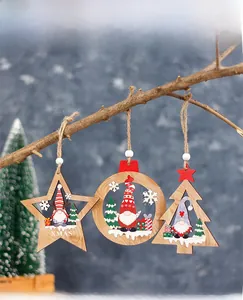 Detailed view of hollow wooden Christmas gnomes hanging ornaments on rustic branches