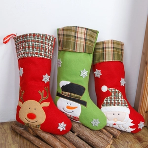 Drie kerstsokken met rendier, sneeuwpop en Kerstman op een houten standaard