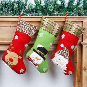 Drie kerstsokken met kerstman, sneeuwpop en rendier op een houten open haard