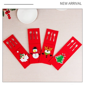 Flat lay of four felt Christmas cutlery holders with Santa, snowman, and reindeer motifs