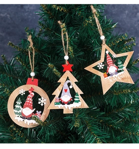 Detail of laser-cut wooden Christmas ornaments with gnome designs on a pine tree