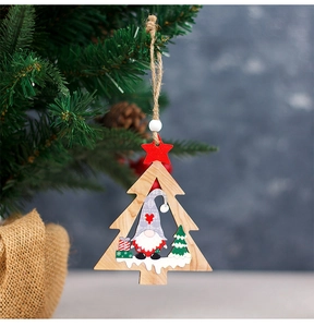 Close-up of wooden Christmas tree ornament with painted gnome and twine on a branch
