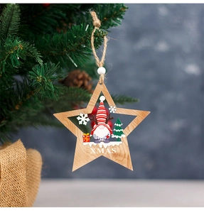 Detail of wooden star ornament with gnome and XMAS text hanging on a Christmas tree