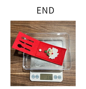 Detail view of felt Santa cutlery holder on a scale showing 11.8g weight