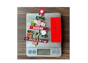 Detailed view of DIY wooden Christmas tree ornament on a scale weighing 38.1 grams
