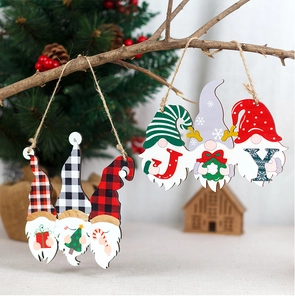 Macro detail of wooden Christmas gnomes with JOY letters hanging on festive branches