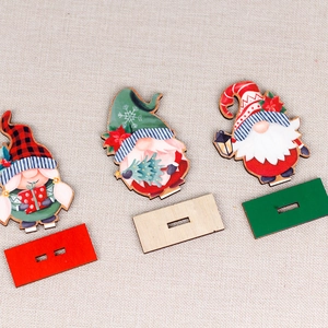 Three wooden Christmas gnomes on bases with festive red, green, and plaid hat patterns