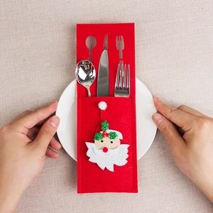 Christmas felt cutlery holder with cartoon Santa Claus design on a white ceramic plate