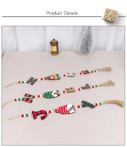 Detail of Christmas wooden bead garland with tassels and festive plaid letter pendants