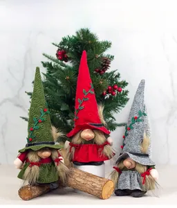 Three Christmas gnomes with embroidered hats and long beards on rustic wooden stands