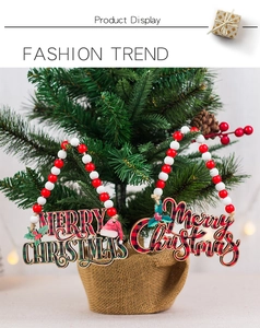Detail view of Merry Christmas wooden hangers with buffalo plaid and red wood beads on tree