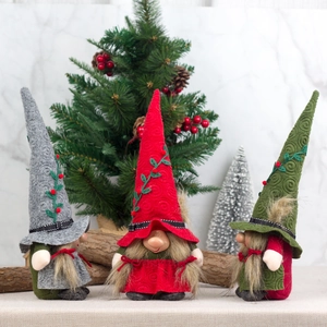 Three Christmas gnomes with spiral pointed hats and fluffy beards in a festive woodland setting