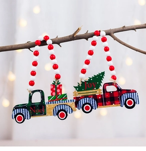 Close-up of wooden Christmas truck ornaments with beads hanging on a branch