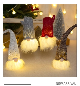 Close-up of lighted Christmas gnome ornaments with sequin hats and warm LED glow