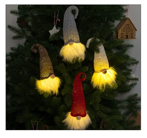 Detail of glowing knitted Christmas gnomes with warm LED lights and sparkling sequins