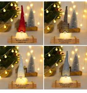Detail of four glowing LED Christmas gnomes with sequined hats and warm lighted beards