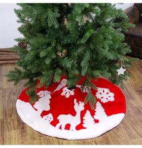 Detail of red Christmas tree skirt with white reindeer pattern and plush faux fur edge