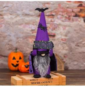 Detail of Halloween purple gnome doll with wizard hat and a HALLOWEEN sign on wood