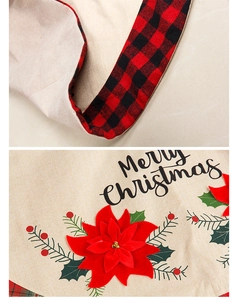 Detail of burlap Christmas tree skirt with red poinsettia and buffalo plaid trim
