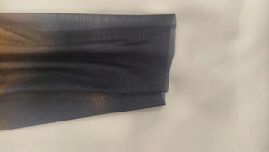 Macro detail of breathable mesh fabric showing the elegant gradient texture and fine pores