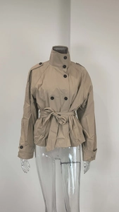 Detail of khaki double-breasted short trench coat with high collar and belted waist