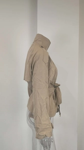 Detail of khaki cropped trench coat featuring classic epaulettes and adjustable waist belt