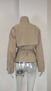 Detailed back view of short khaki trench coat with storm flap and adjustable waist belt