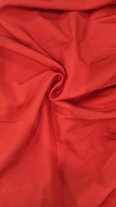 Macro shot of vibrant red polyester fabric showing fine texture and soft draping quality