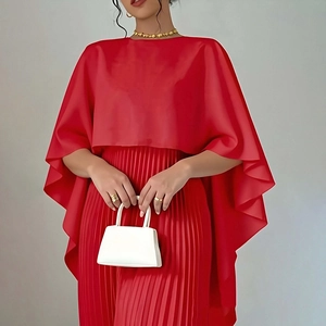 Dettaglio dell'abito rosso stile mantella con gonna a pieghe in tessuto satinato di lusso