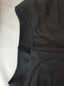 Dettaglio della trama in raso nero e delle cuciture per questo set aderente da donna