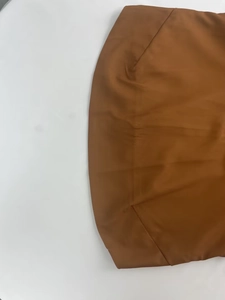 Detailed view of the brown wide-leg jumpsuit fabric texture and vertical seam stitching