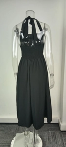 Detail of black halter dress featuring an open back and elastic smocked waist design