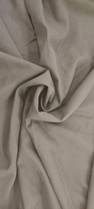 Close-up of elegant taupe halter neck dress fabric with soft texture and smooth drape