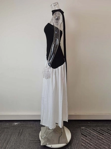 Detail of minimalist black and white maxi dress with neck tie and contrast design