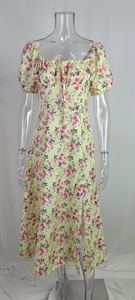 Detail of floral yellow dress featuring drawstring square neck and puff sleeves