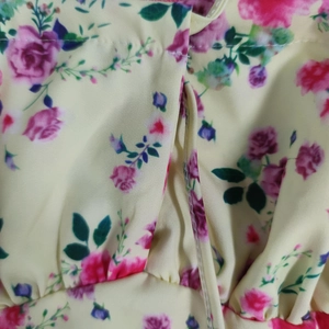 Close-up of floral chiffon fabric with pink roses and detailed side seam stitching