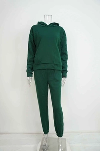 Detail of dark green two-piece tracksuit featuring hooded sweatshirt and elastic joggers