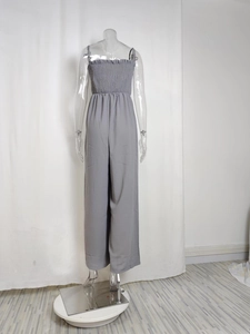 Close-up of smocked bodice and thin straps on a grey high-waist wide-leg jumpsuit