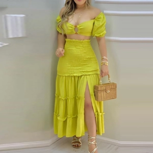 Détail du crop top vert citron à épaules dénudées et jupe à plusieurs niveaux fendue