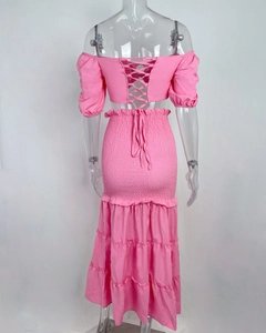 Détail d'un ensemble rose deux pièces avec haut à lacets et jupe longue à volants