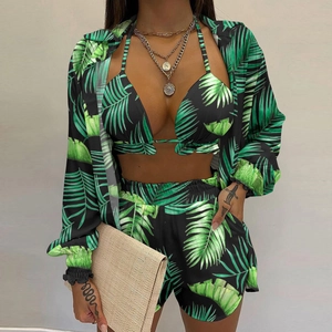 Detailed view of women's three-piece beach set with green palm leaf print and chiffon shirt
