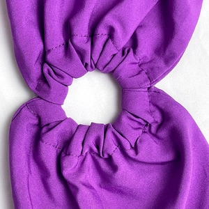 Détail de la taille d'une robe violette avec smocks élastiques et découpe évidée précise