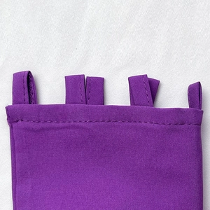 Gros plan des passants en tissu violet avec des coutures de précision durables