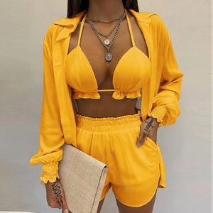 Detail of yellow three-piece beach set with halter top, high waist shorts and shirt