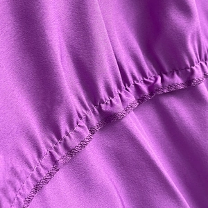 Gros plan sur le tissu violet élégant avec coutures doubles et plis élastiques raffinés