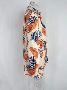 Detail of long sleeve resort shirt featuring vibrant tropical orange and blue leaf prints